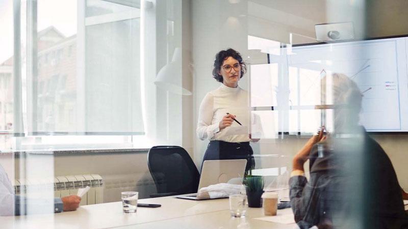 Reunión de trabajo donde una mujer está de pie hablando